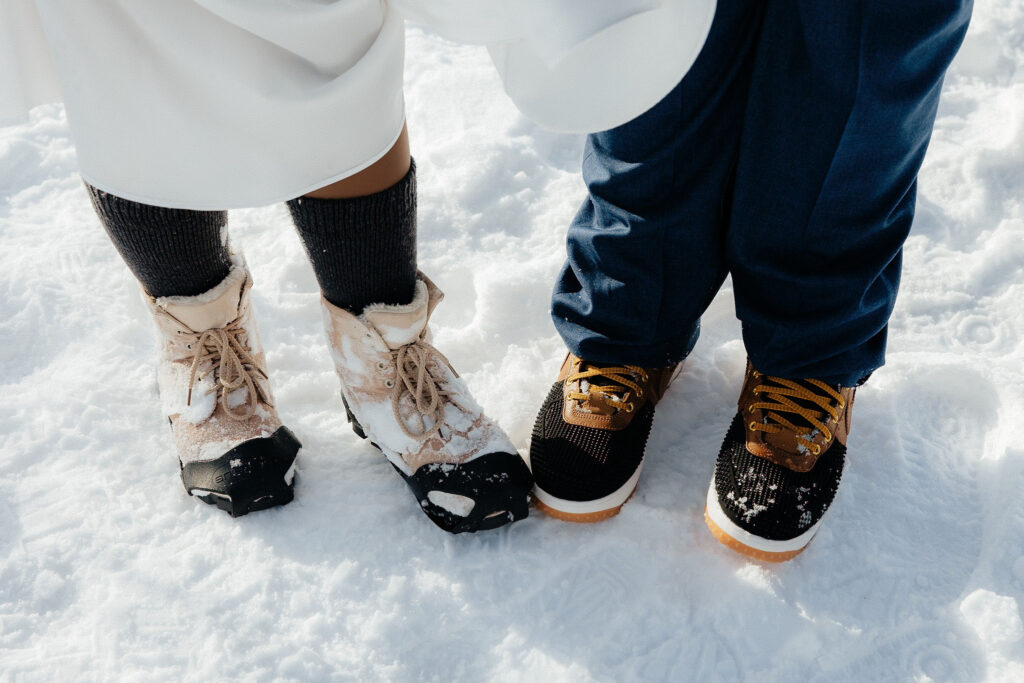 bride and grooms feet standing in the snow