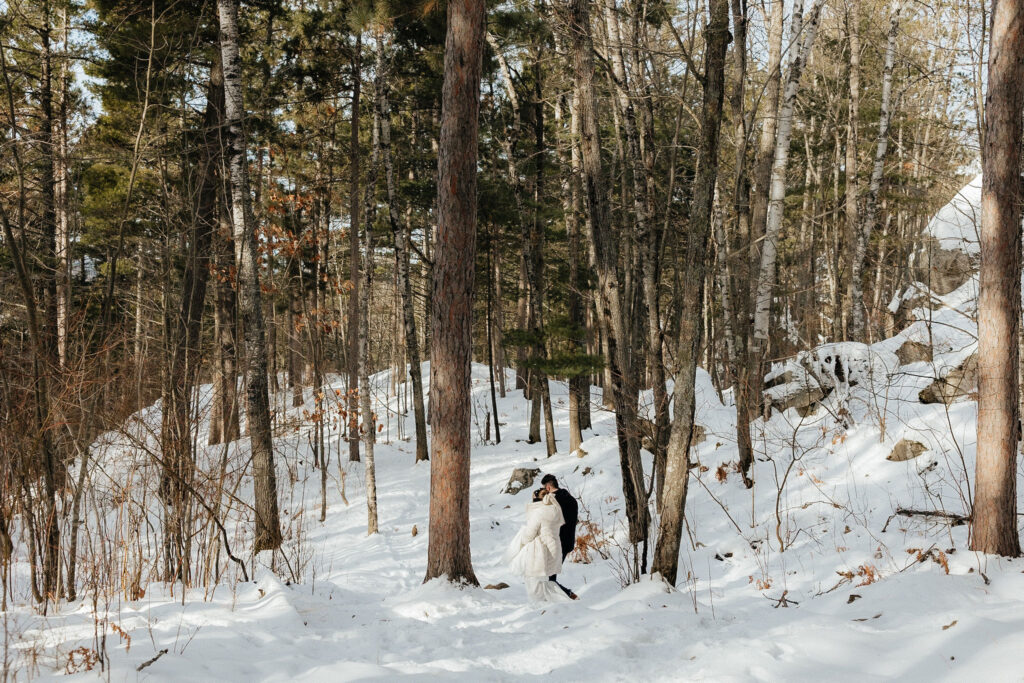 bride and groom hiking through the woods 