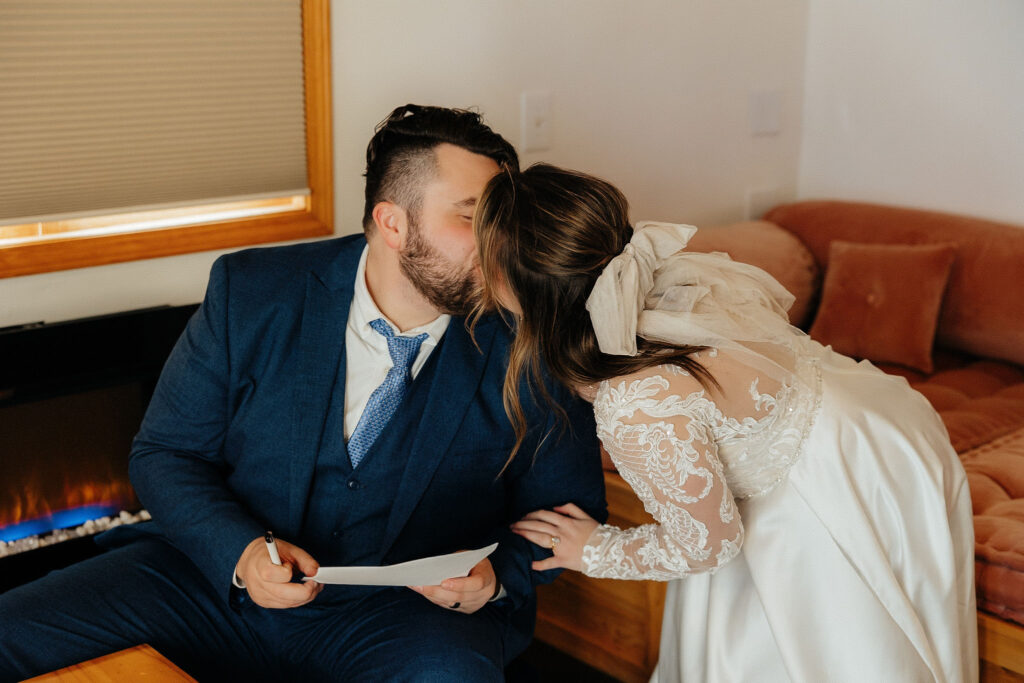 bride and groom kissing inside a cabin